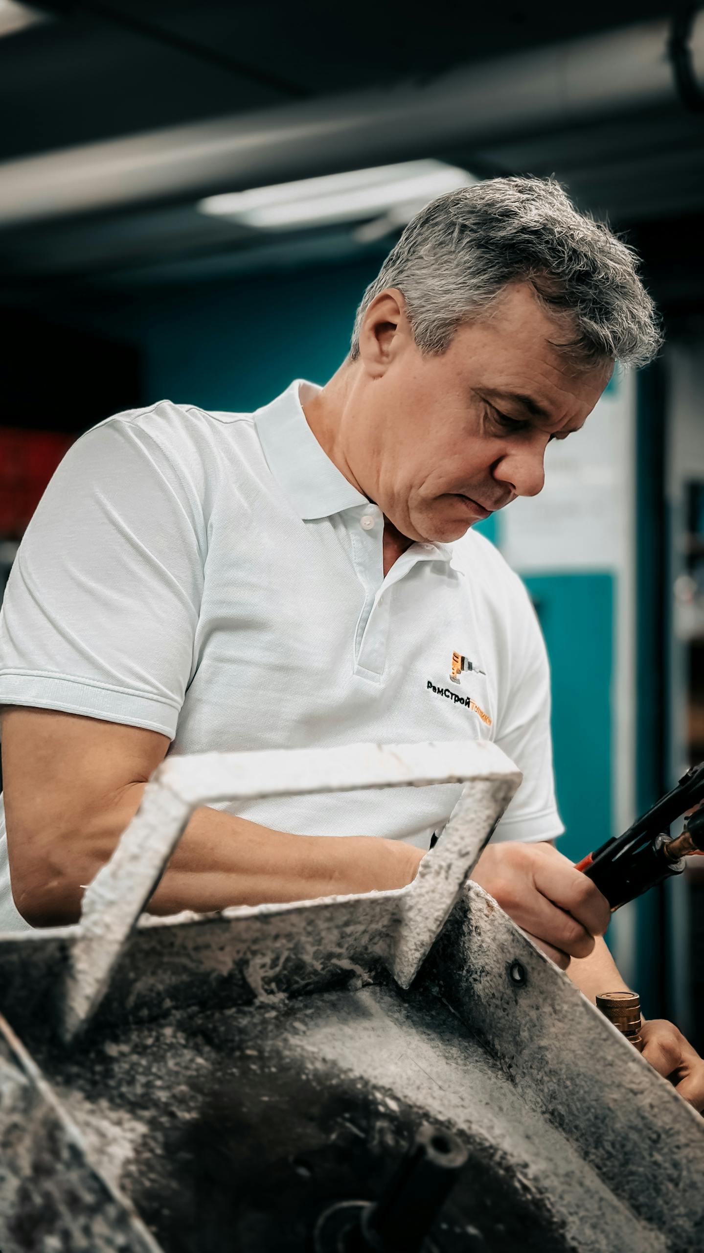 Focused male technician working on machinery in an industrial setting.