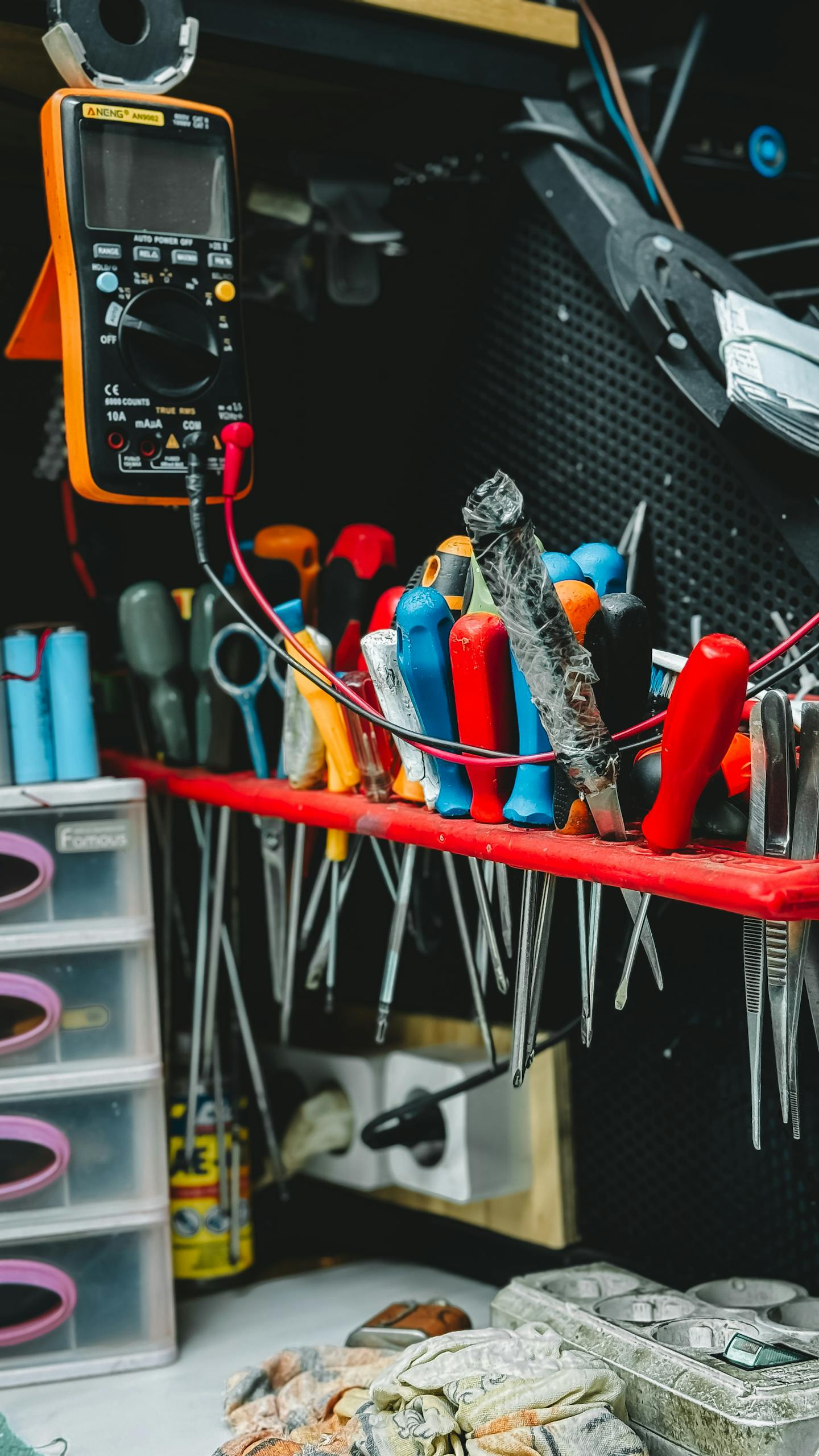 Neatly arranged tools on a workbench, featuring pliers, screwdrivers, and a multimeter.